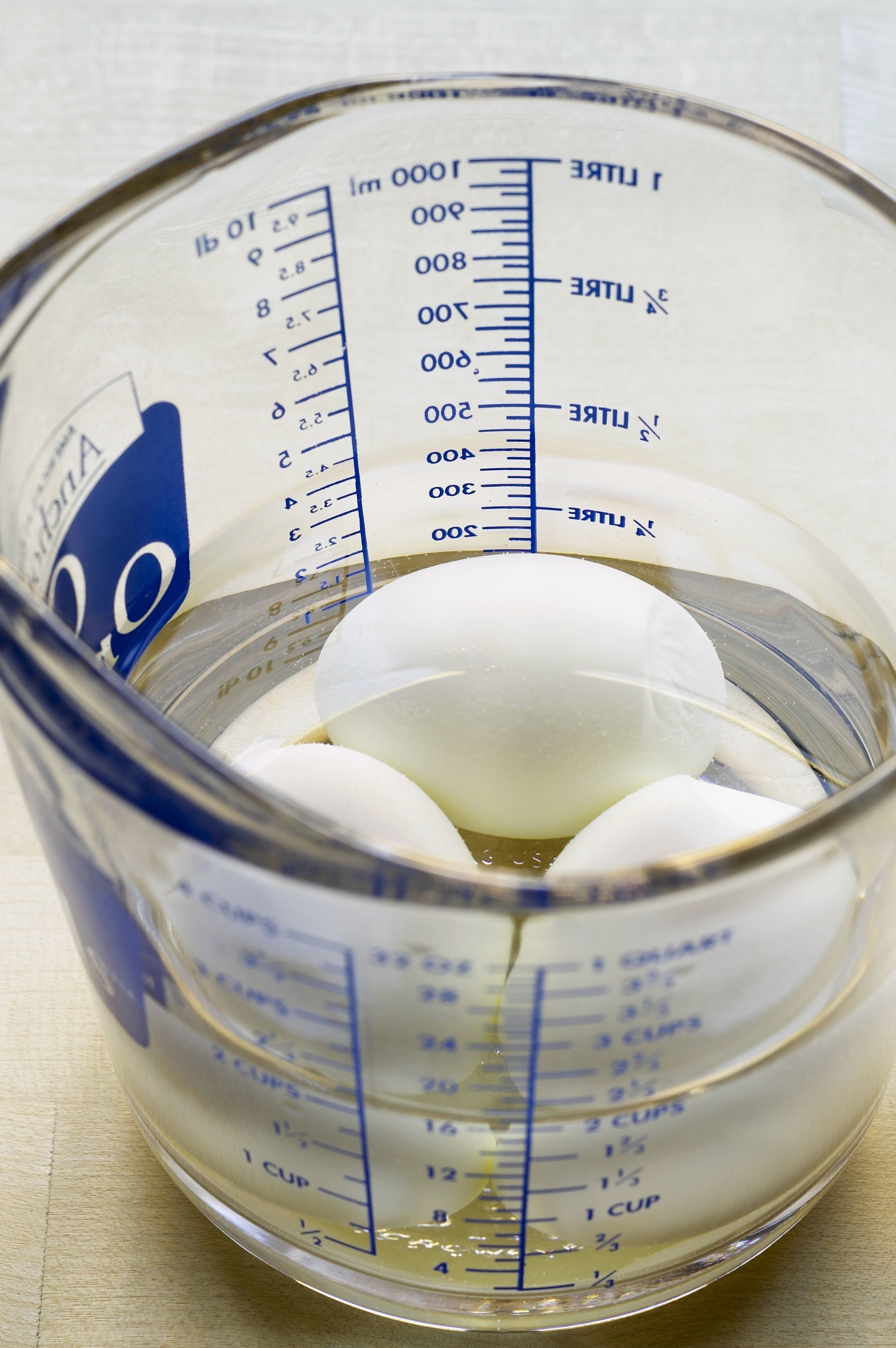 用600ml熱水加400ml室溫水，把雞蛋放水浸10分鐘，因為溫水浸蛋會令全蛋打發效果更好。然後壓爛2隻香蕉，合桃洗乾淨後抹乾。用牛油紙包好活底盤，並在蛋糕盤向上掃油，這樣會令焗蛋糕的時候升高。