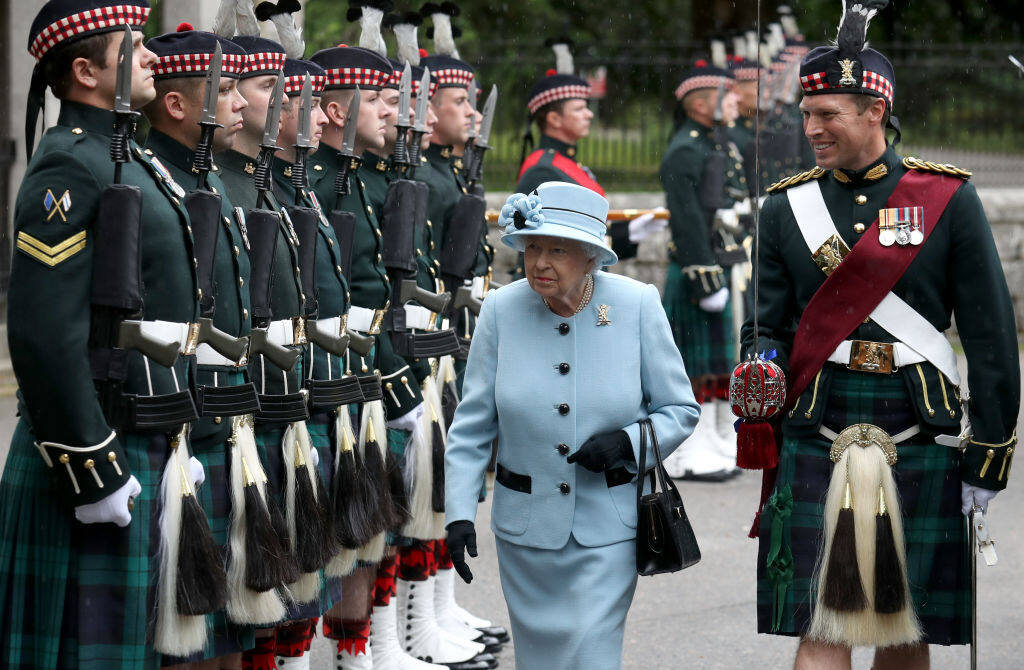 英女皇近日抵達英格蘭步兵團，身穿淺藍色套裝，襯上黑色鞋袋，神采飛揚。